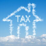 A house shape and word tax on blue sky