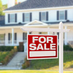 Home For Sale Real Estate Sign in Front of Beautiful New House.