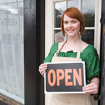 Woman holding open sign