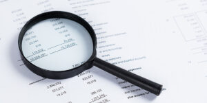 Magnifying glass on financial statement paper. Analyzing busines